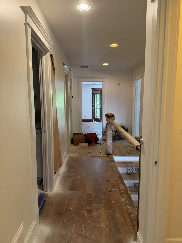 Hallway floor protection and materials staged during a remodel