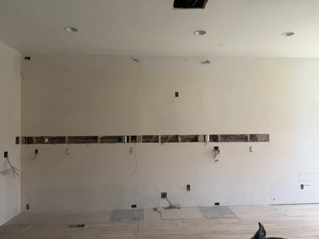 Kitchen wall open for electrical and fixture planning before cabinets and backsplash